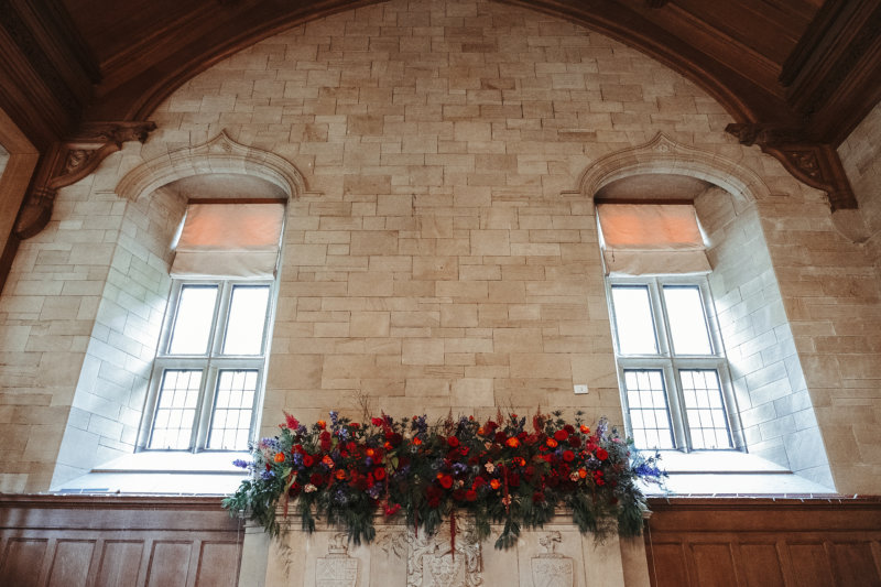 Scottish Castle Windows, Achnagairn Castle Ballroom Decorations, Autumn Colour Scheme Inspiration, Tall Ceiling Wedding Venue, Scottish Wedding Flowers, Red and Blue Wedding Flower Theme, Scottish Weddings with Thistles.